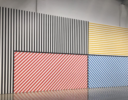 Sol LeWitt, Wall Drawing #368: The wall is divided vertically into five equal parts. The center part is divided horizontally and vertically into four equal parts. Within each part are three-inch (7.5 cm) wide parallel bands of lines in four directions in four colors. In each of the other parts, three-inch (7.5 cm) bands of lines in one of the four directions. The bands are drawn in color and India ink washes. Red, yellow, blue, ink, India ink 3” 